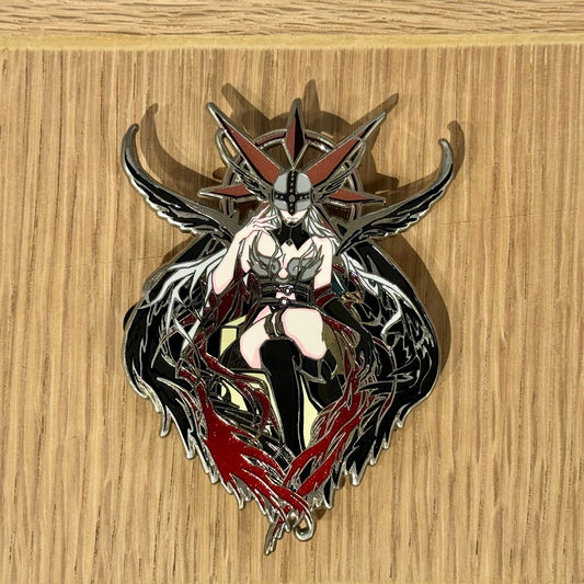 Close-up of gothic angel inspired enamel pin with red and black wing details