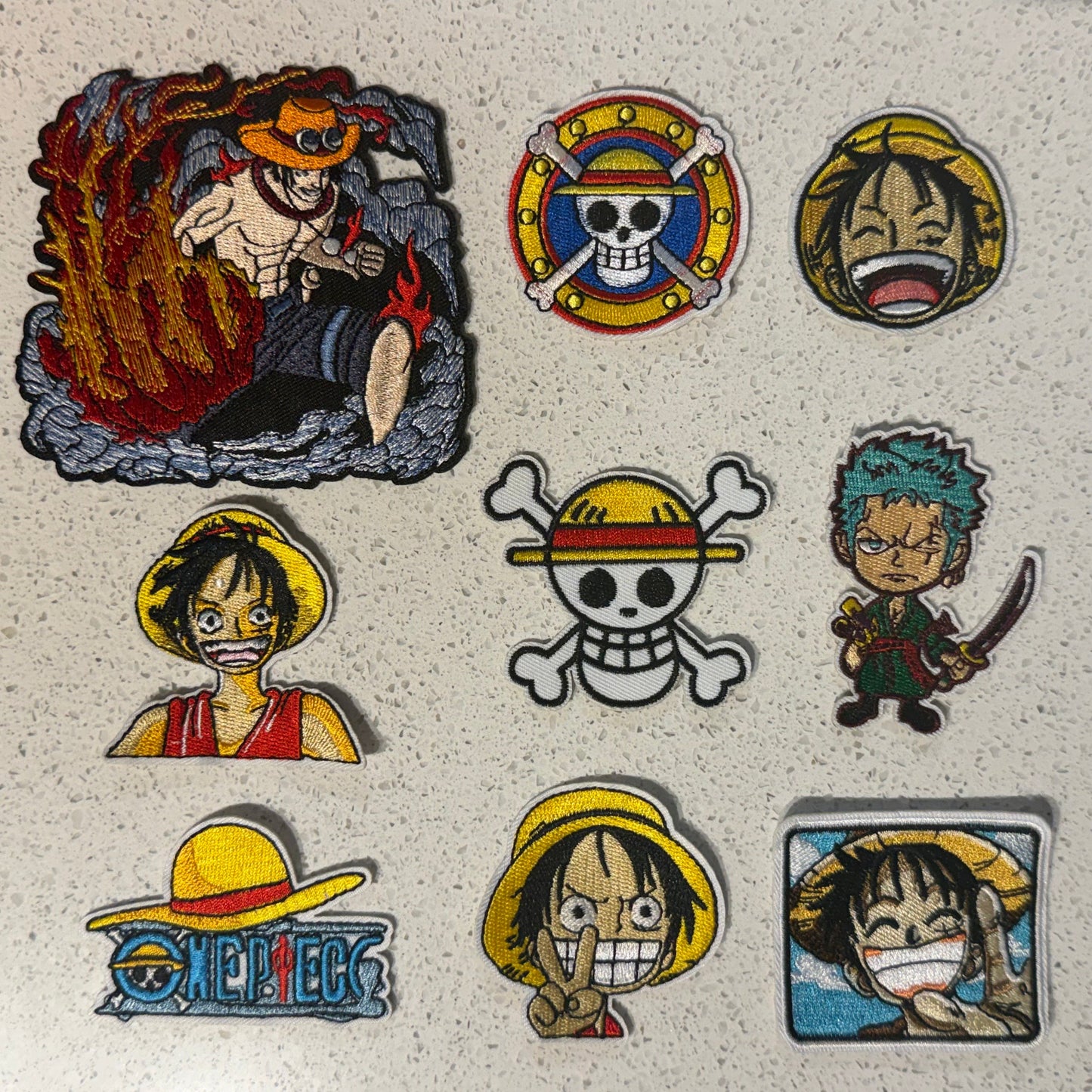 Nine One Piece embroidered patches featuring Luffy, Zoro, Ace and colourful Straw Hat Pirates logo designs.
